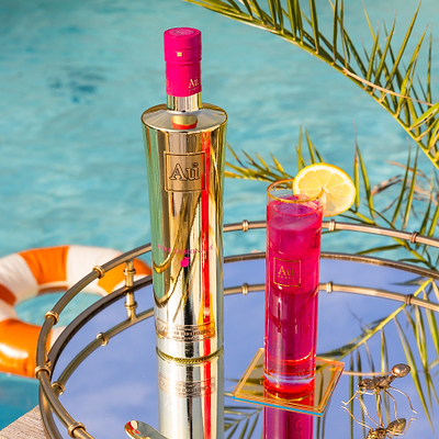 Au Vodka Pink Lemonade bottle and a glass of pink lemonade cocktail with a lemon slice