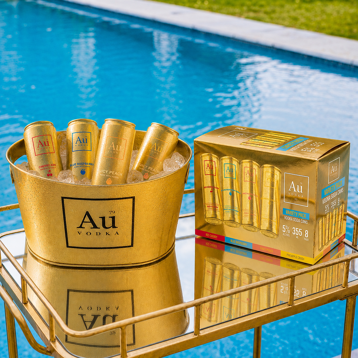 Au Vodka variety pack cans in a gold ice bucket next to a gold box on a mirrored table by a pool