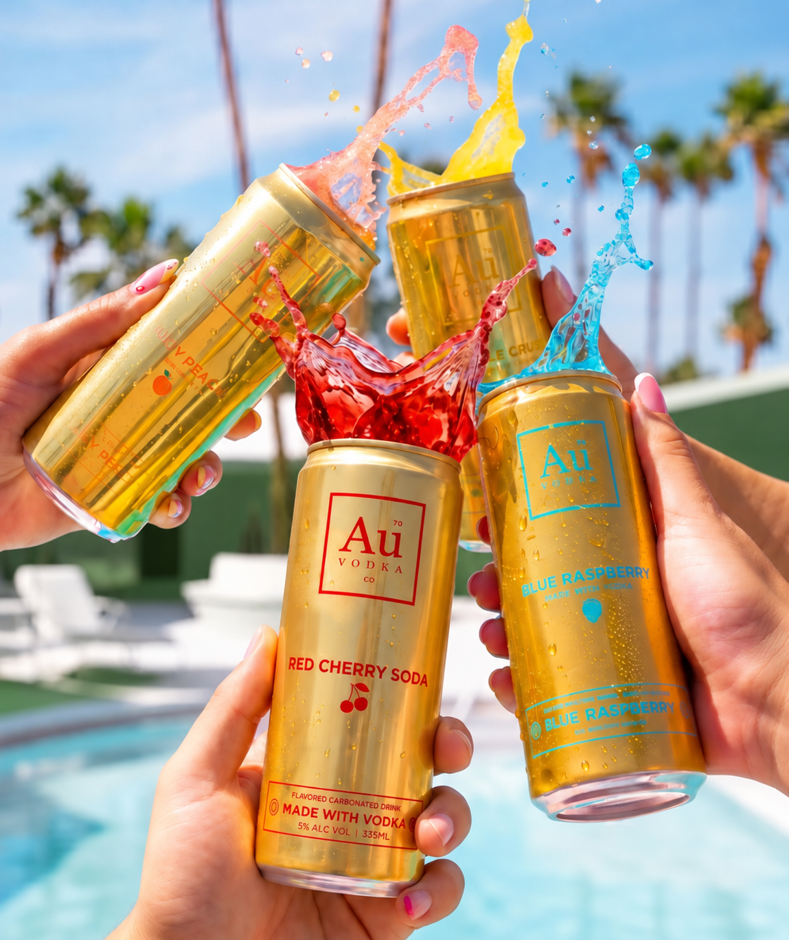 Four hands holding metallic gold cans of Au Vodka pre mixed drinks in front of a pool with palm trees. The cans are labeled Red Cherry Soda, Blue Raspberry, Pineapple Crush & Juicy Peach, with colorful liquid splashes bursting from the open tops.