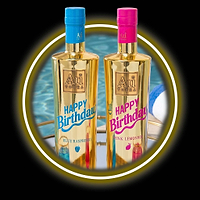 Two Au Vodka Happy Birthday bottles, blue raspberry and pink lemonade, on a gold tray by a pool