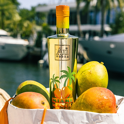 Au Vodka USA 750ml Miami Mango bottle with mangoes in a white bag, boats in background
