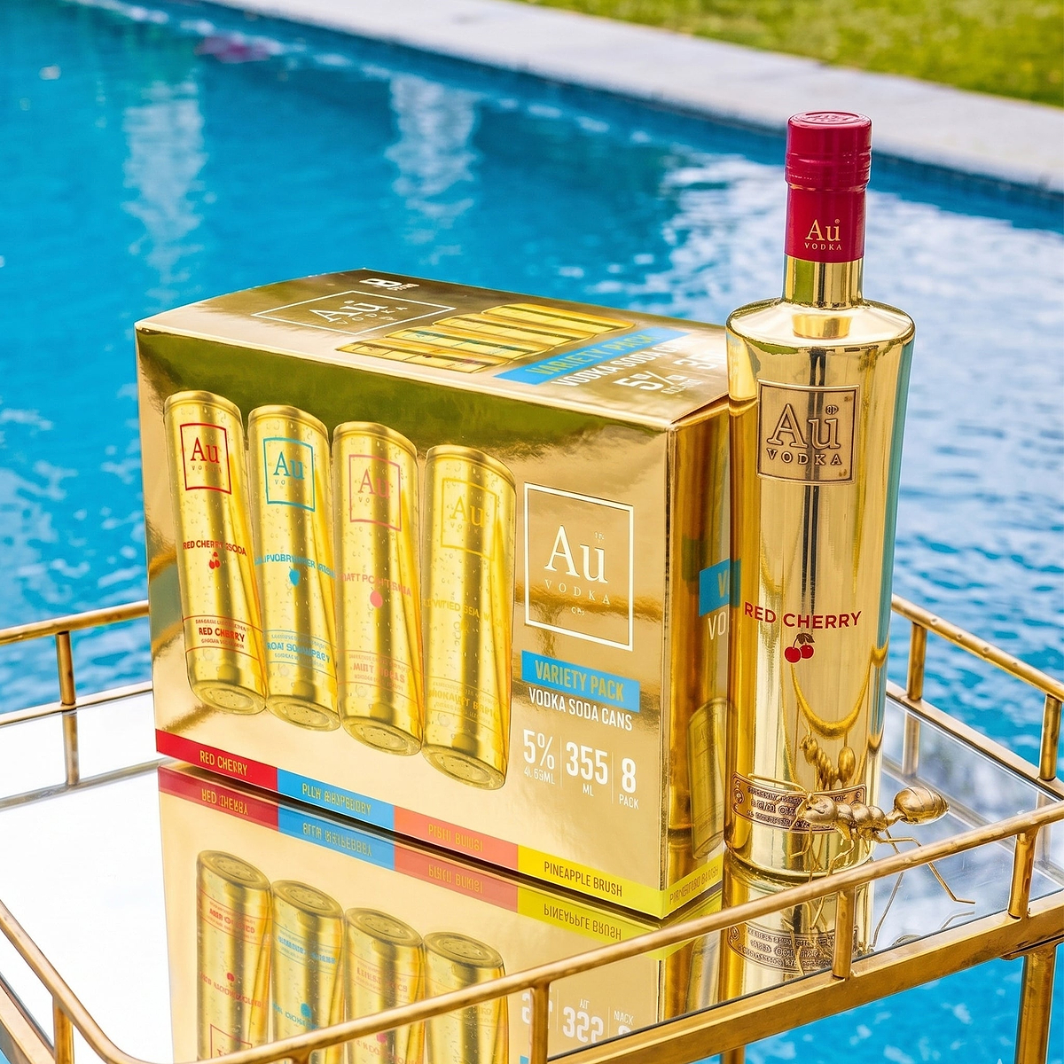 Au Vodka USA Red Cherry bottle and variety pack of vodka soda cans on a gold bar cart by a pool