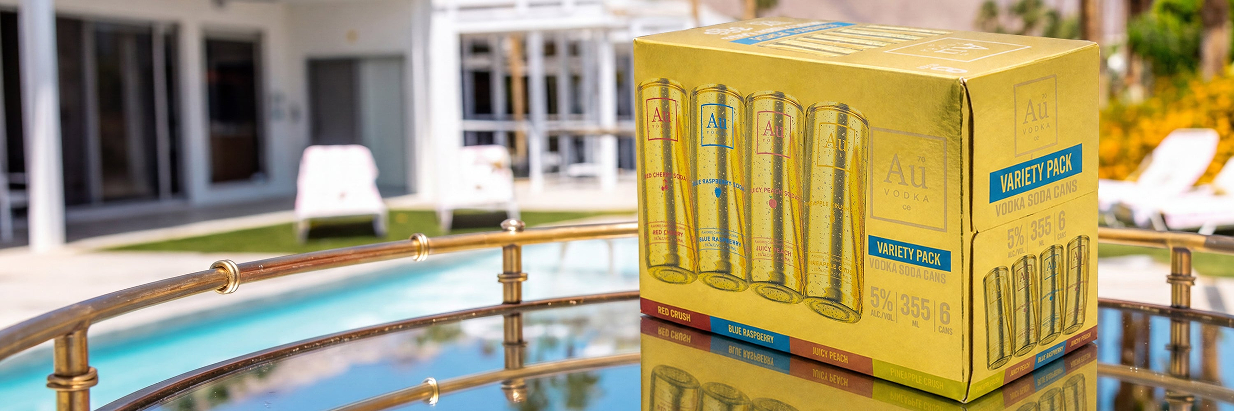 Au Vodka Soda Cans Variety Pack on a mirrored table by a pool