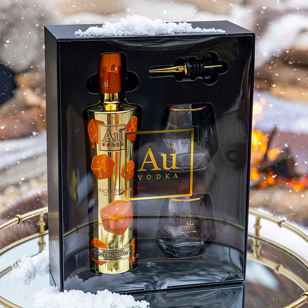 Au Vodka bottle and glass set in a decorative box with a warm glow background
