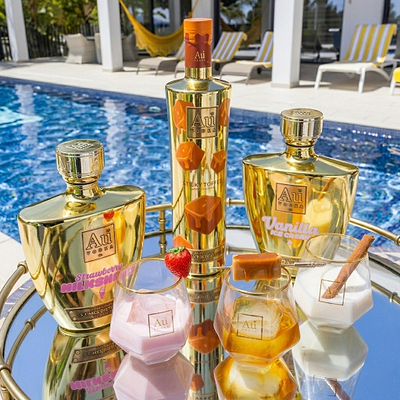 Au Vodka USA bottles in Sticky Toffee, Strawberry Milkshake, and Vanilla Ice Cream flavors by a pool