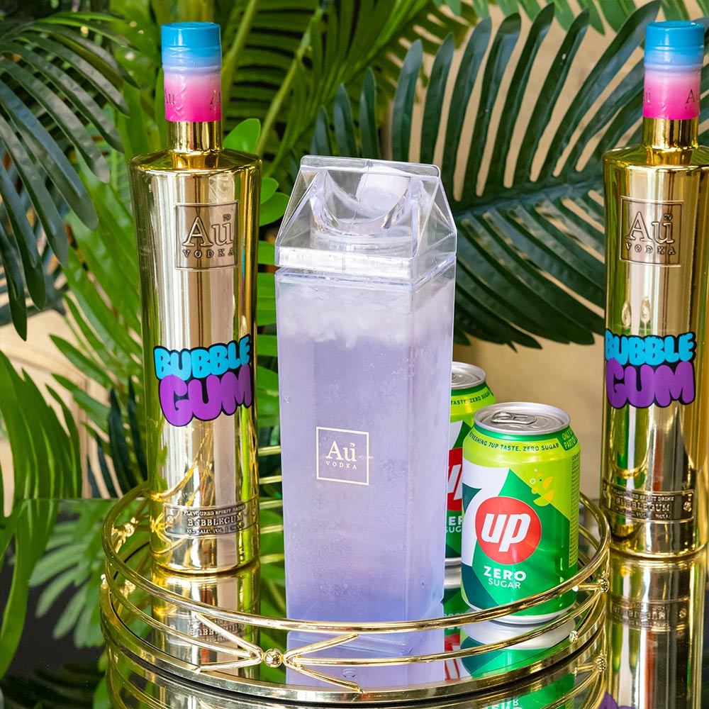 Au Vodka bottles next to a clear carton of purple cocktail and a can of 7up