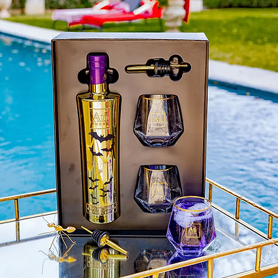 Au Vodka Black Grape gift pack with bottle, two glasses, and pourer on a tray by a pool