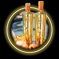 Two Au Vodka Juicy Peach bottles, a cocktail with orange slice, and a peach on a gold tray