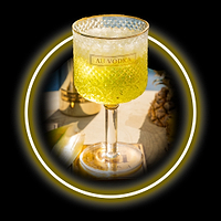 Au Vodka cocktail in a textured glass with ice, pineapple in the background