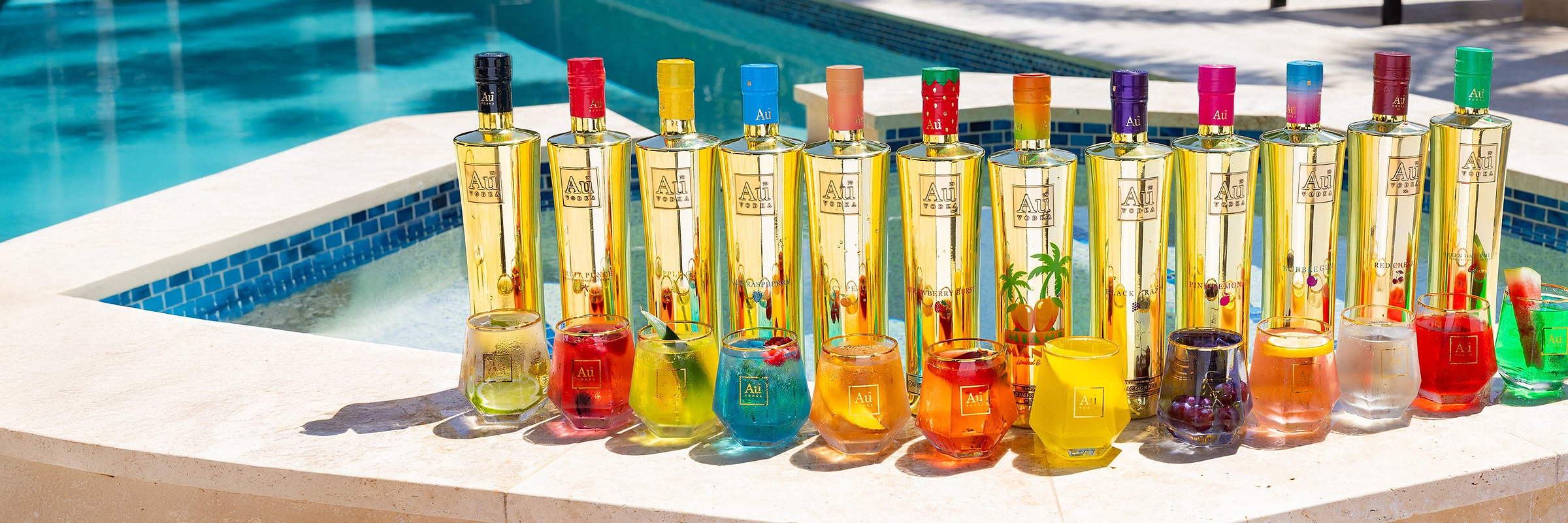 Au Vodka bottles and cocktails by a swimming pool