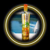 A bottle of mango flavored vodka with a tropical design, set against a blurred background of a swimming pool