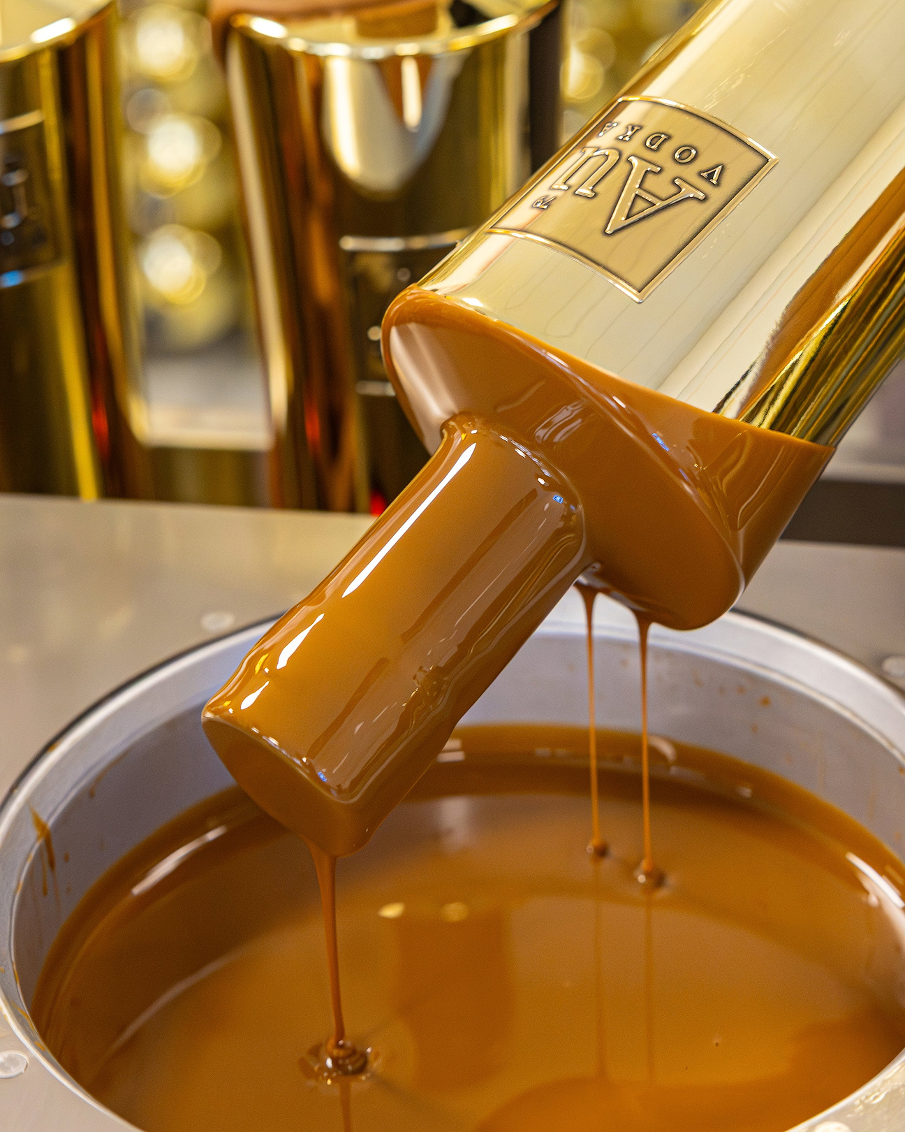 Au Vodka bottle being dipped into a vat of liquid chocolate