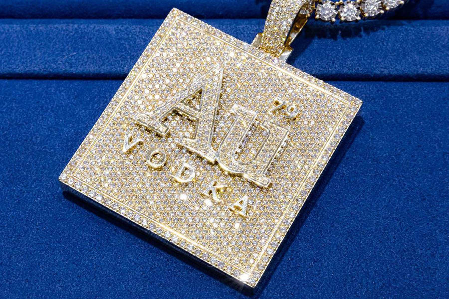 Gold Au Vodka pendant with diamonds on a blue background
