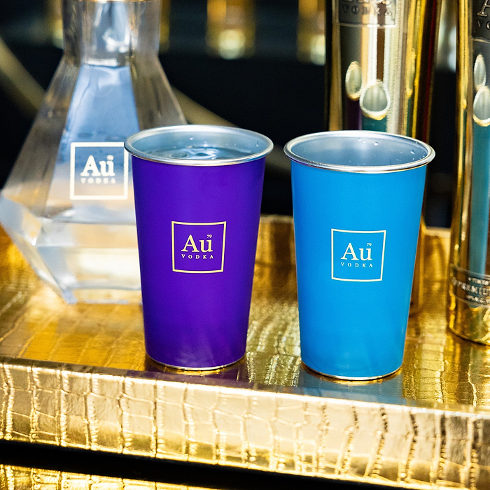 Au Vodka USA purple and blue merchandise cups with Au Vodka logo on a gold crocodile texture tray