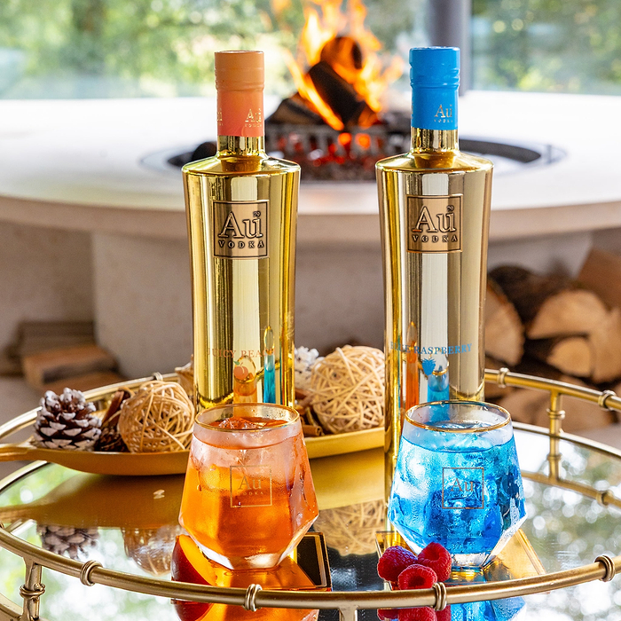 Au Vodka Juicy Peach and Blue Raspberry bottle bundle with matching cocktails on a gold tray