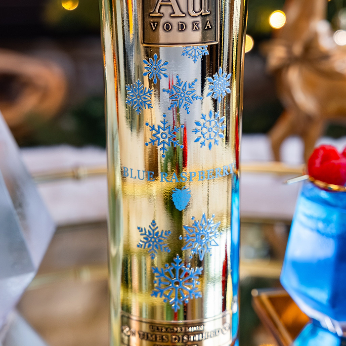 Close up shot of the Snowflake Print Design on the Au Vodka Blue Raspberry Bottle on a blurry background