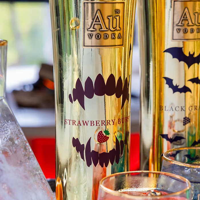 Two bottles of Au Vodka with Halloween-themed labels on a blurred background