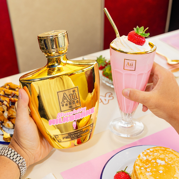 Au Vodka Strawberry Milkshake & Au Vodka Sundae Glass on a diners table with dessert items.