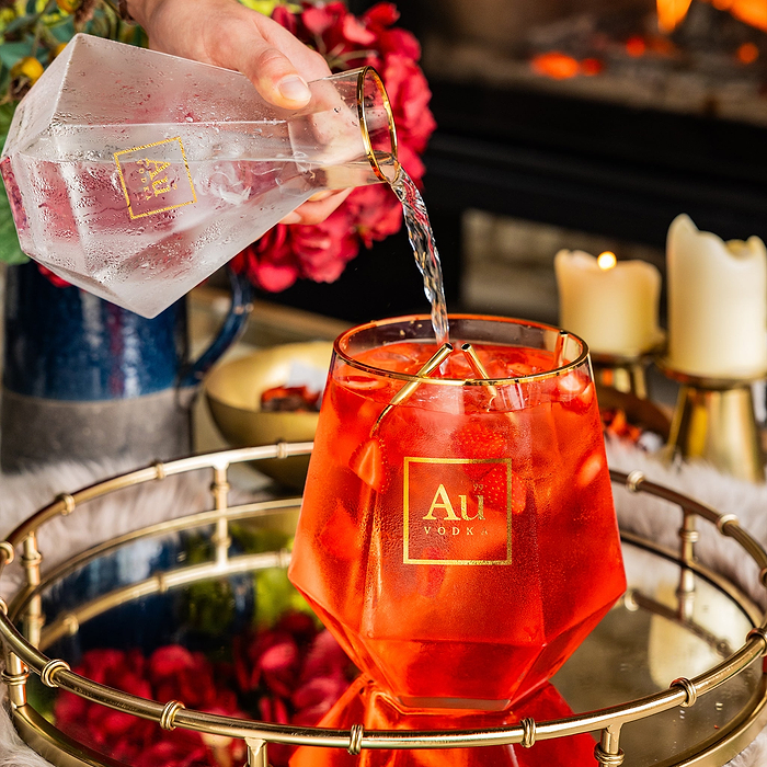 Au Vodka glassware being filled with liquid from a diamond shaped carafe