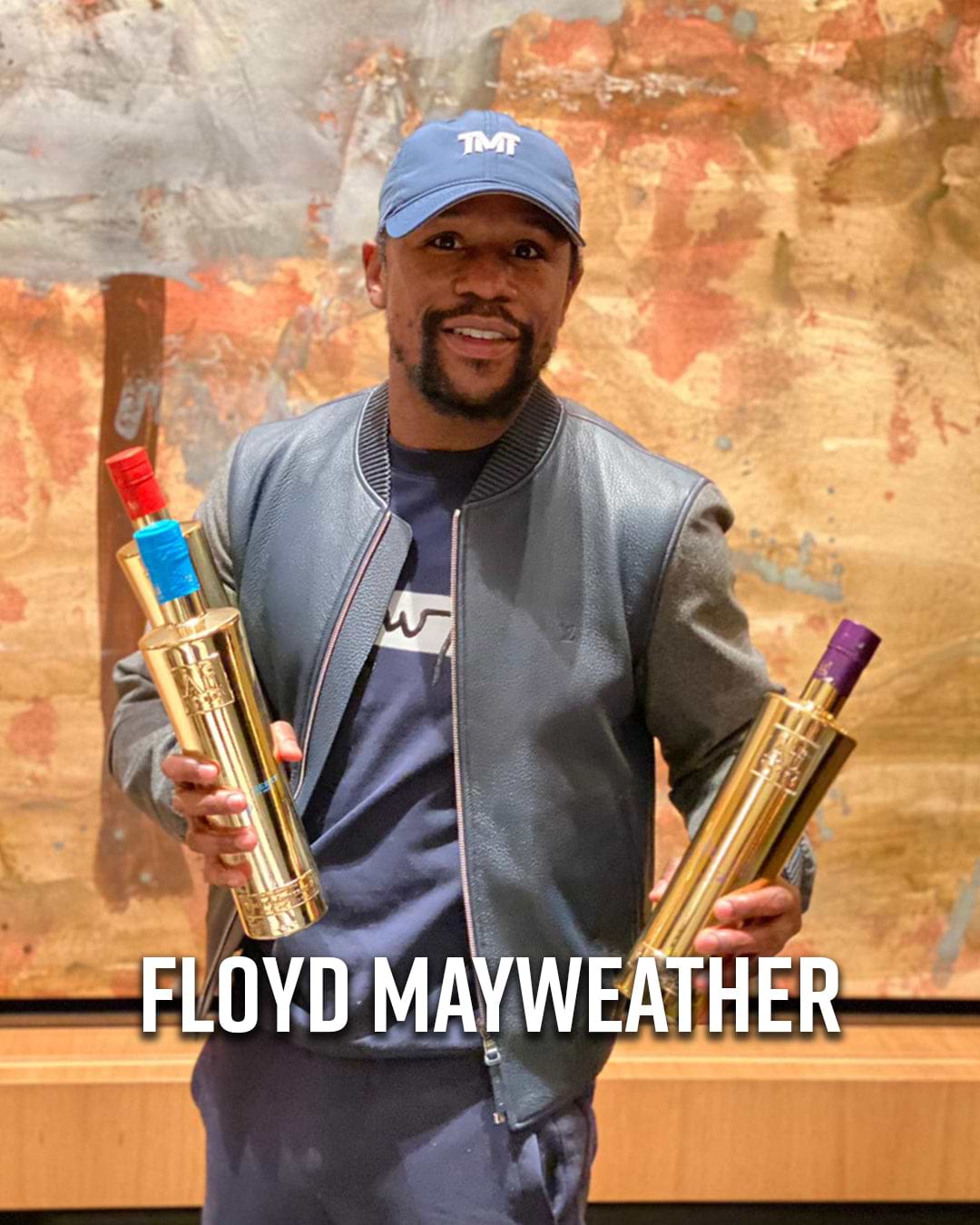 Floyd Mayweather holding two gold bottles of Le Grand Saint sparkling wine