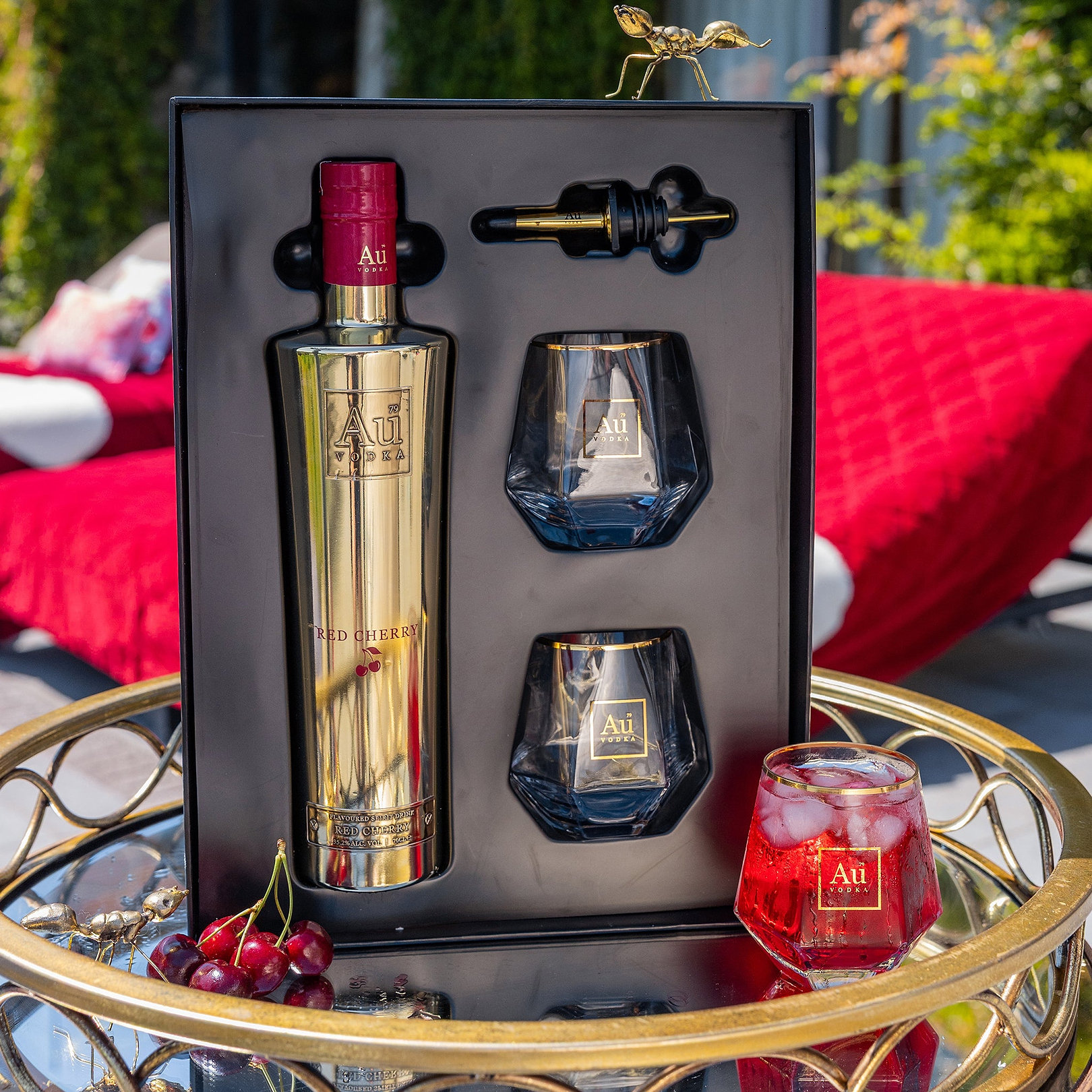 Au Vodka Red Cherry gift set with bottle, two glasses, and pourer on a gold tray