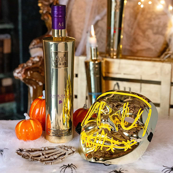 Au Vodka Black Grape bottle with Halloween decorations including a light up mask and mini pumpkins