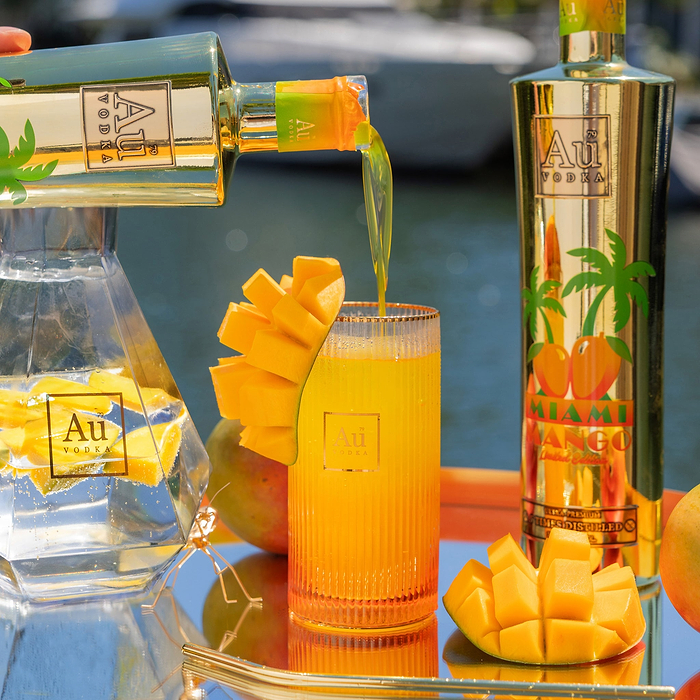 Au Vodka USA Miami Mango being poured into a glass with mango slices