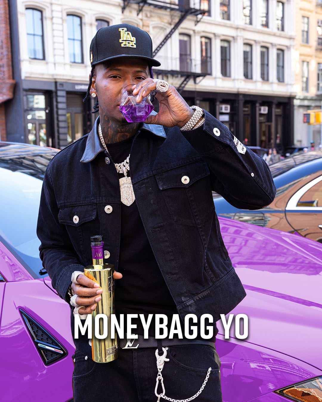 Moneybagg Yo holding a gold bottle and a glass with purple liquid next to a purple car