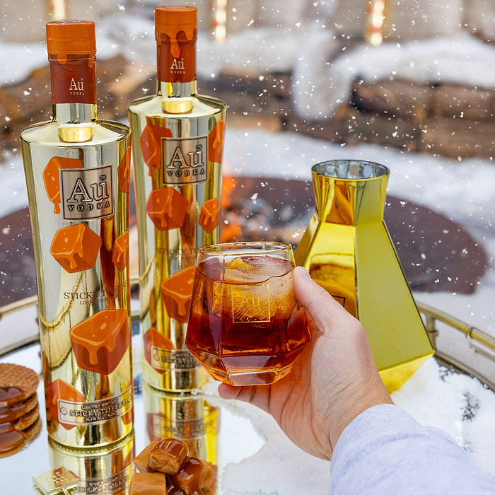Bottles of Au Vodka with a glass of Sticky Toffee in a snowy setting