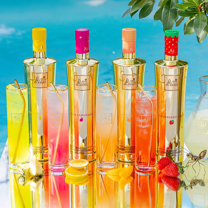Au Vodka USA Bottle Bundles with four gold bottles and four cocktails on a reflective surface