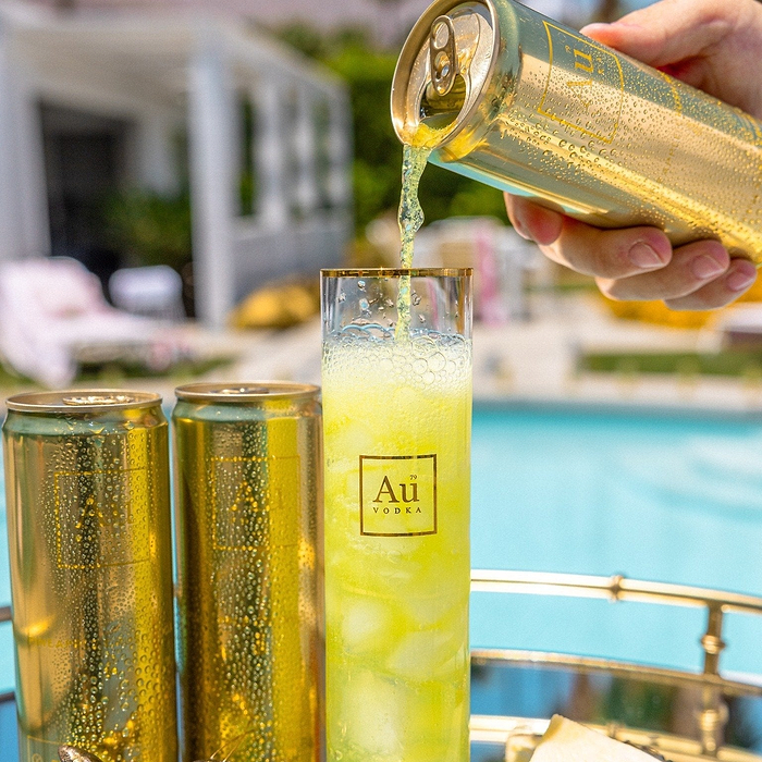 Au Vodka USA Pineapple Crush being poured from a can into a glass by a pool
