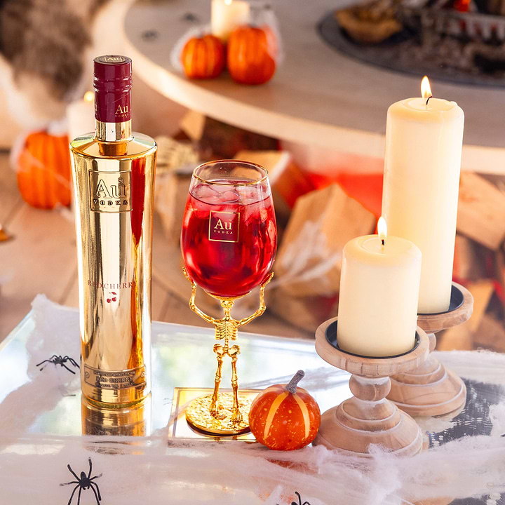 Au Vodka Red Cherry bottle and skeleton stem glass bundle with candles and pumpkins