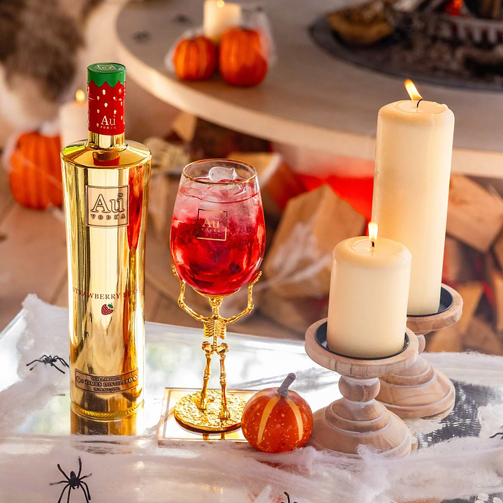 Au Vodka Strawberry Burst bottle and skeleton stem glass bundle with candles and pumpkins