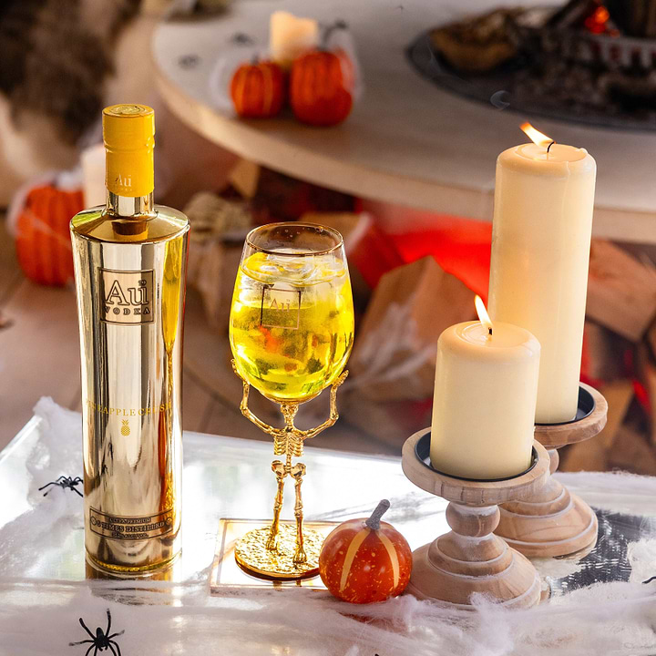 Au Vodka Pineapple Crush bottle and skeleton stem glass bundle with candles and pumpkins