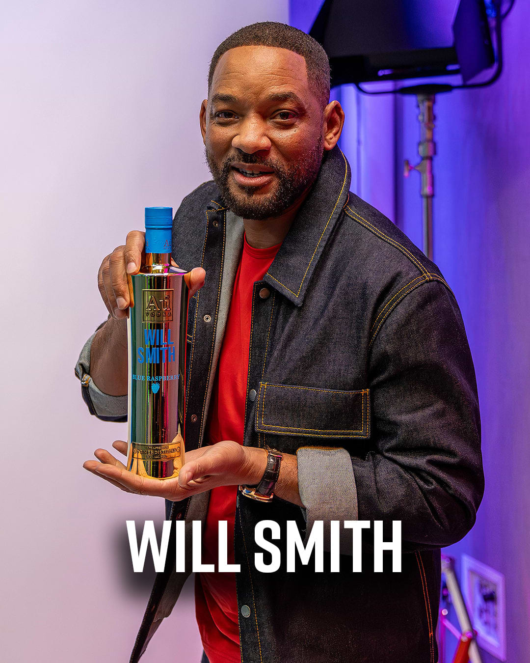 Will Smith holding a gold bottle of Au Vodka Blue Raspberry