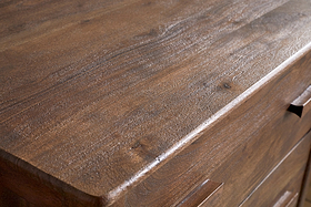 Close-up of the nkuku Anbu Acacia Chest of Drawers in Washed Walnut, showcasing its smooth, polished surface, natural wood grain, and subtle brown tones. Two drawer handles add style to this elegant bedroom storage piece.