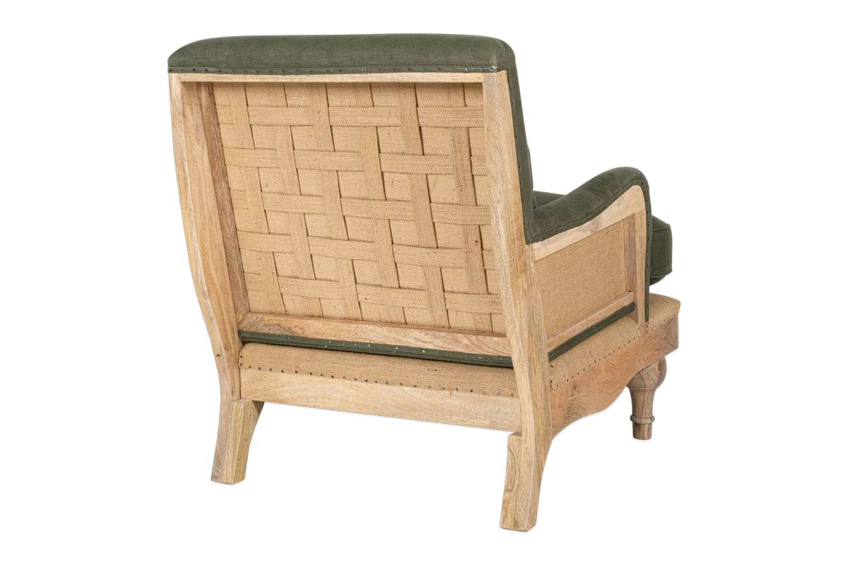 The nkuku Abe Deconstructed Linen Armchair - Olive features an exposed mango wood frame, woven cane back, olive linen upholstery, slightly turned legs, and a rustic unfinished look.