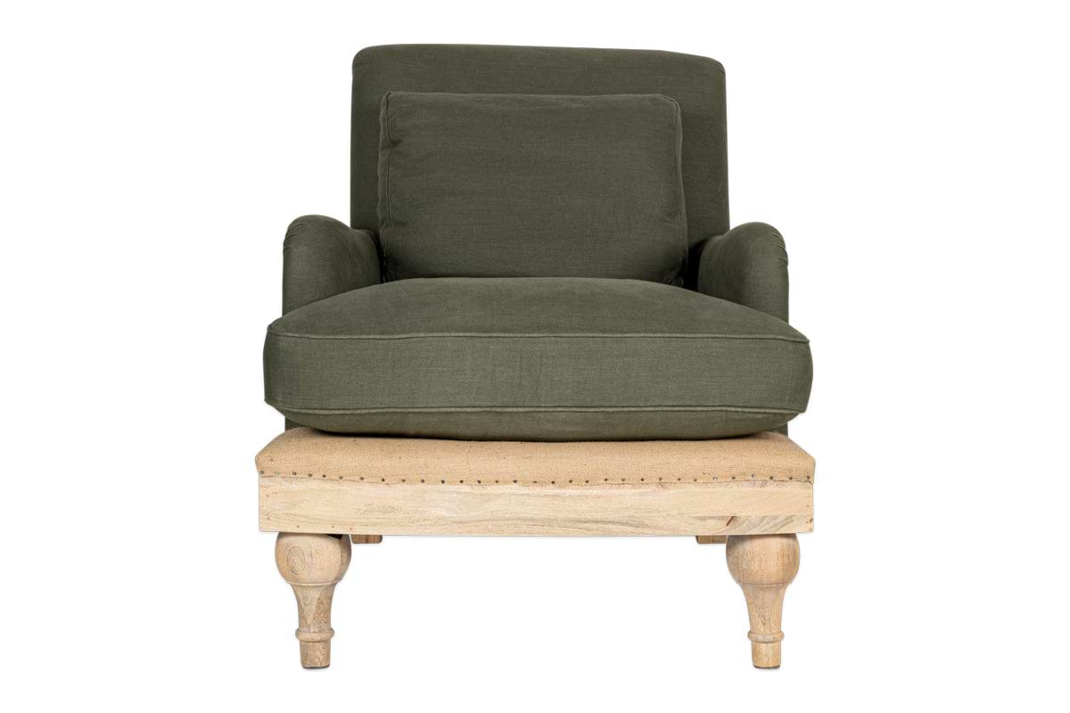 The nkuku Abe Deconstructed Linen Armchair - Olive features linen upholstery, a square backrest, cushioned seat, matching pillow, mango wood frame with decorative studs, and turned wooden legs. Set against a plain white background.