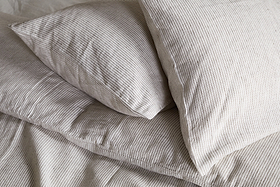 Two pillows in nkukus Borba Hemp & Cotton Housewife Pillowcases in Espresso are neatly arranged on a bed, creating a soft and cozy look.