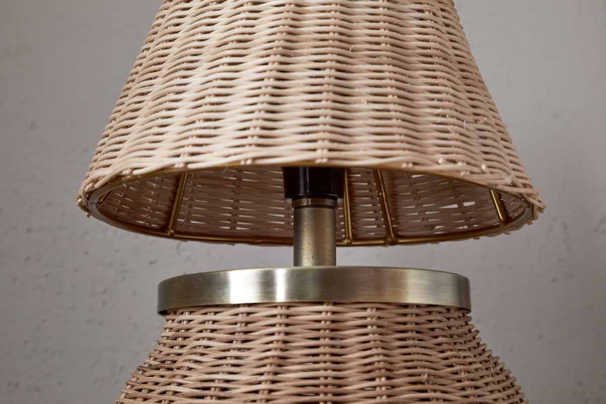 The Cija Rattan Table Lamp by nkuku features a natural woven shade and base, accented with a metallic band and stem—perfect for adding style to any bedside table.