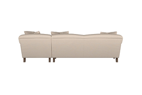 The Deni Large Corner Sofa by Nkuku, shown in Brera Linen Pebble, is pictured from the back with two seat sections, four back cushions, and wooden legs. This modern sofa features clean lines and soft linen upholstery that exemplify British quality craftsmanship, all set against a plain white background.