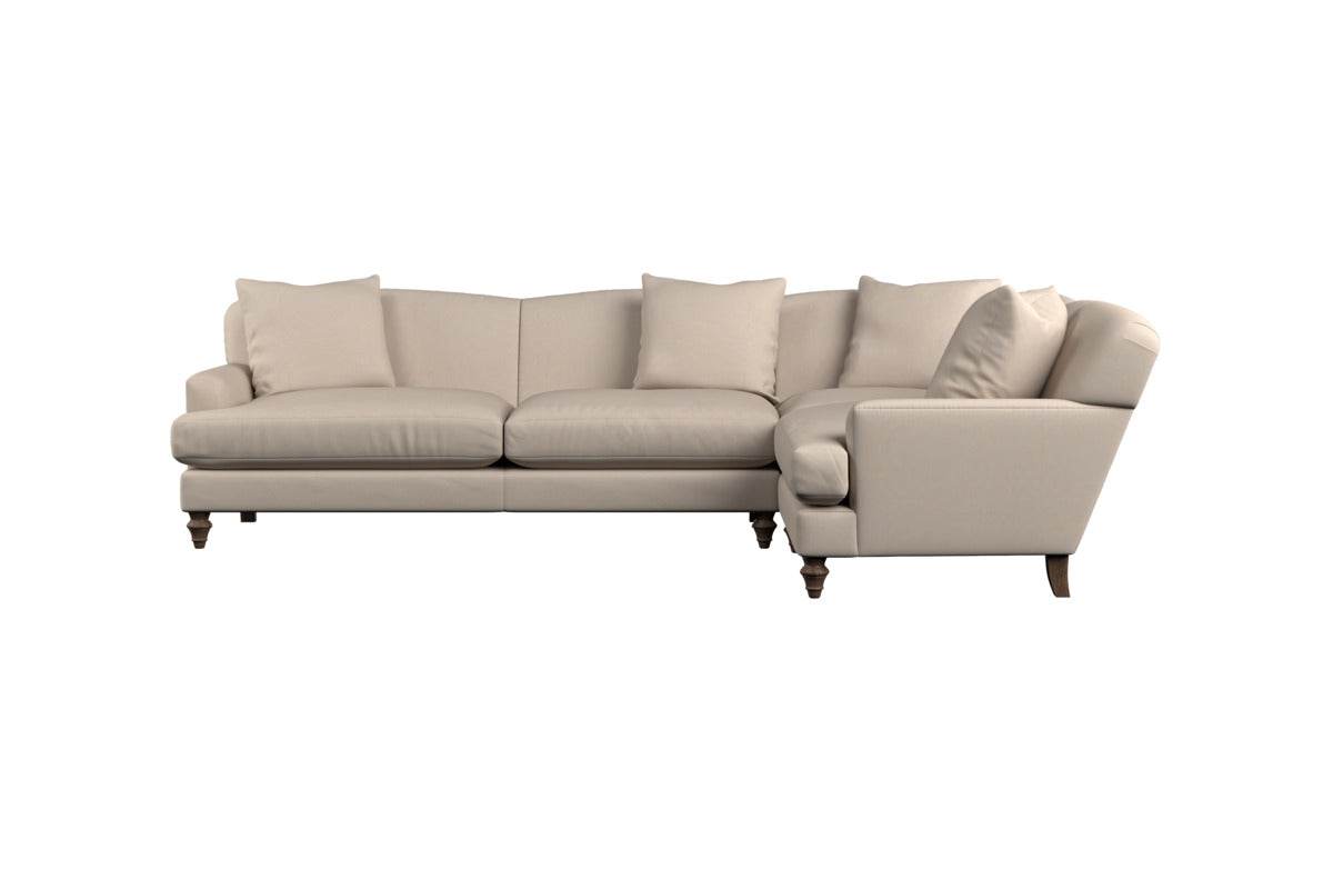 Here’s the revised sentence using your product data: The Deni Large Corner Sofa - Brera Linen Sage by Nkuku is an L-shaped sectional in a soft beige-green hue, featuring plush seat and back cushions, four matching throw pillows, gently rolled arms, and dark wooden legs that embody classic British quality. Its elegant linen upholstery stands out beautifully against a plain white background.