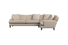 The Deni Large Corner Sofa - Brera Linen Sage by Nkuku is an L-shaped sectional in a soft sage hue, featuring four seat cushions and four matching back pillows. It showcases rolled arms, wooden legs, and premium linen upholstery that reflects British-quality craftsmanship. The sofa is pictured against a white background.