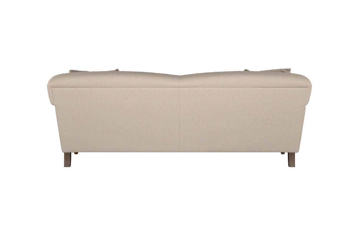 The Deni Large Corner Sofa by Nkuku, shown here in Brera Linen Smoke, features smooth linen upholstery in a neutral beige shade. Its simple and functional design includes slightly curved armrests, divided backrest cushions, and four short wooden legs. With clean lines and versatile coloring, this modern sofa suits a wide range of interiors.
