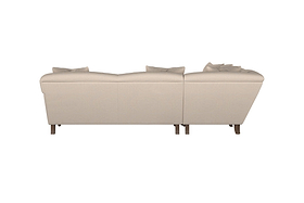 The Deni Large Footstool by Nkuku, shown here in Brera Linen Charcoal, is photographed from the back to highlight its handcrafted details and solid wooden legs. Its washed linen upholstery in a deep charcoal hue adds to its understated elegance, while subtle stitching hints at its modular design. Set against a plain white background, the footstool’s neutral color and minimalist form are emphasized.