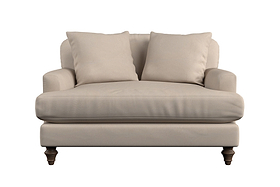 A beige handmade large footstool, the "Deni Large Footstool - Brera Linen Pebble" by Nkuku, with plush seat cushion, linen upholstery, and dark wooden legs is centered and isolated on a white background.