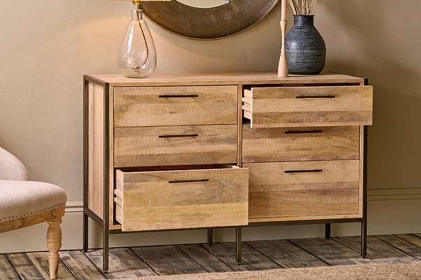 The Dasai Mango Wood Chest of Drawers by nkuku features warm mango wood, dark metal legs, and two columns of drawers—three per side, with the top two on the right open—offering a perfect blend of style and storage.