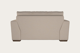 Guddu Large Right Hand Chaise Sofa by Nkuku, shown from the back in Brera Linen Indigo—a modern design featuring clean lines, wide armrests, wooden block feet, and a slightly overhanging cushioned backrest that exemplifies exceptional British craftsmanship—all set against a plain white background.