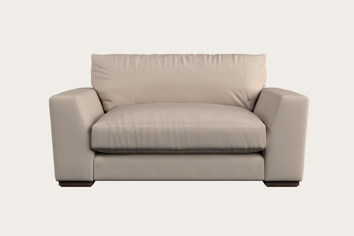 Introducing the Guddu Large Right Hand Chaise Sofa by Nkuku in Brera Linen Indigo—a modern handcrafted piece showcasing British craftsmanship. This sofa features wide, square armrests, a thick seat cushion, and a plush back cushion, all set in a minimalist design with low rectangular legs against a plain, light background.