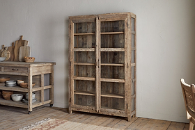 The Ibo Reclaimed Wood & Glass Cabinet - Natural - Wide by nkuku features classic wooden construction, glass panel doors, and antique brass handles for a rustic yet elegant look.